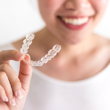 Patient holding Invisalign in Framingham