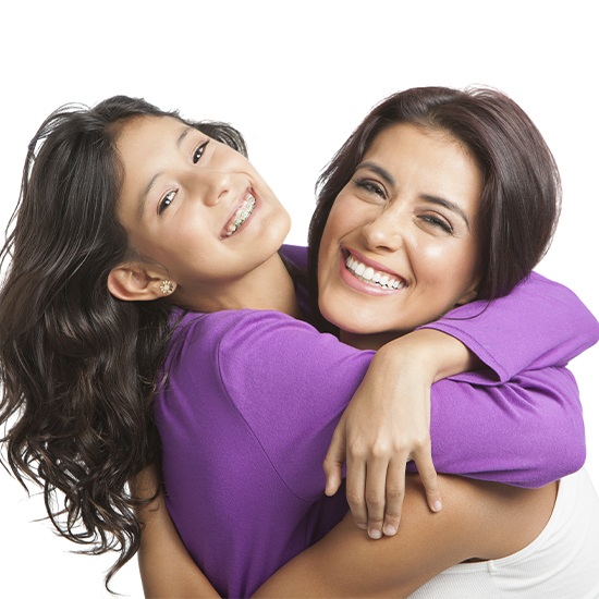 Mother hugging her young daughter after pediatric orthodontics appointment