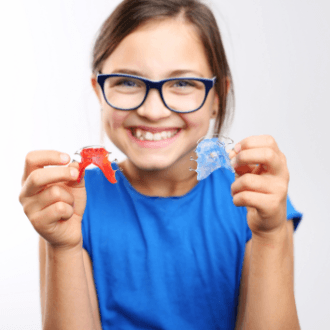Preteen girl holding orthodontic appliances