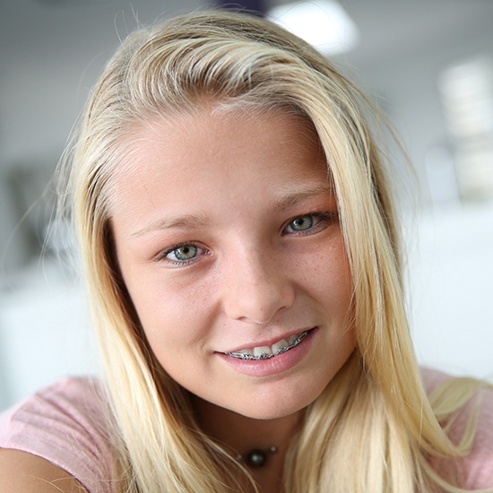 Smiling teen girl with traditional metal braces