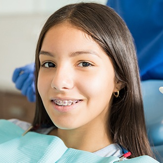 Smiling teen girl with braces in orthodontic treatment chair