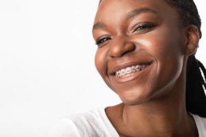 Smiling girl with braces in Framingham on white background