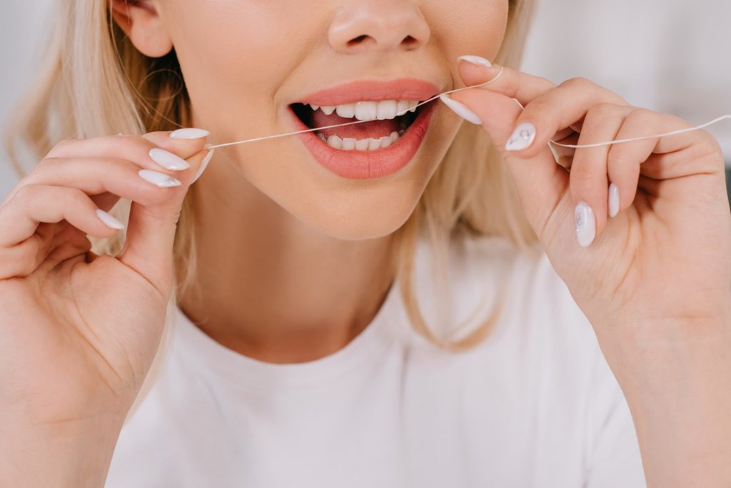 Closeup of woman flossing her teeth