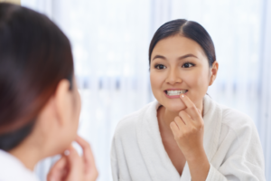 a person examining their teeth in a mirror